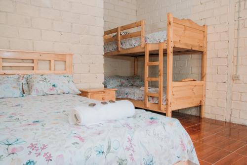 a bedroom with a bed and two bunk beds at Hacienda CacaoyMango in Naranjal