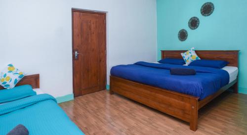 a bedroom with two beds with blue sheets at Gregory House Hostel in Nuwara Eliya