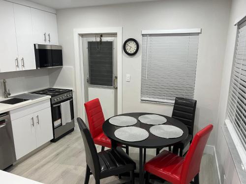 a kitchen with a black table and red chairs at SEA ECHO APPARTMENT MOTEL in Fort Lauderdale