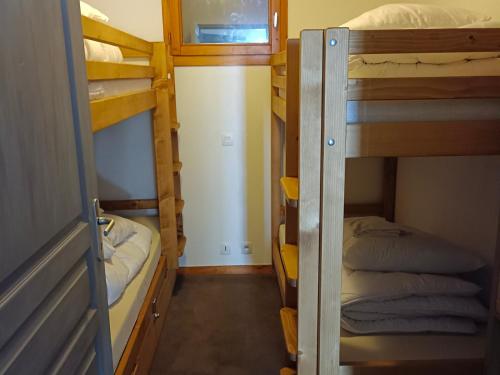 a room with two bunk beds and a window at Charmant 2 pièces rénové, 5 pers, 30m², ski aux pieds, au cœur des Bruyères - Les Menuires - FR-1-178-372 in Les Bruyères