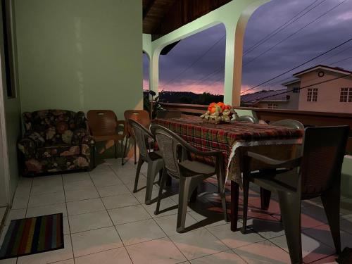 uma sala de jantar com uma mesa e cadeiras numa varanda em Homely environment ideal for a home away from home em Gros Islet
