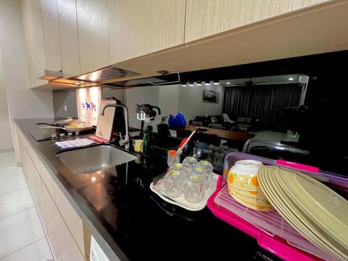 a kitchen with a counter with dishes and a sink at A2801 Green Haven 4Bedroom netflix100mbps By STAY in Masai