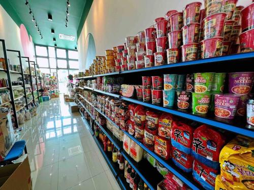 a store aisle with shelves filled with canned food at A2801 Green Haven 4Bedroom netflix100mbps By STAY in Masai