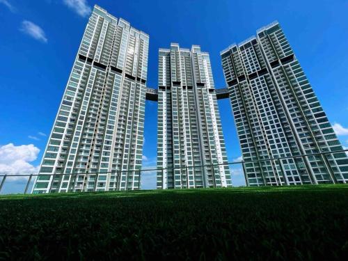 three tall buildings with grass in front of them at A2801 Green Haven 4Bedroom netflix100mbps By STAY in Masai
