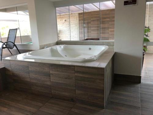 een groot bad in een badkamer met houten vloeren bij Serra Madre Residence in Rio Quente