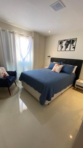 a bedroom with a blue bed and a window at Apartamento altíssimo padrão - Piscina com vista in Mangaratiba