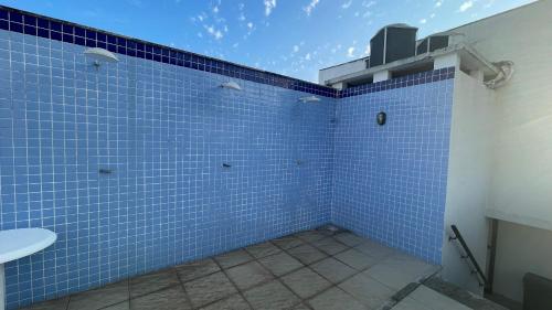 a bathroom with blue tiled walls and a sink at Apartamento altíssimo padrão - Piscina com vista in Mangaratiba