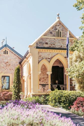 una casa con flores delante en Mount Lofty House & Estate Adelaide Hills - Adults Retreat, en Adelaida