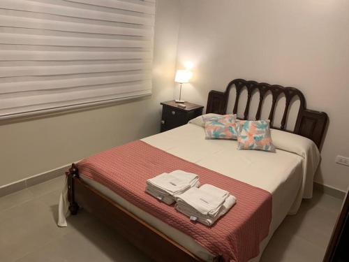 a bedroom with a bed with a suitcase on it at Los Naranjos Departamentos 1 in Concepción