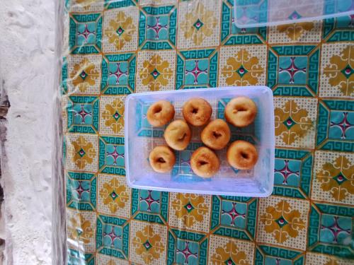 a plastic container of donuts sitting on a tiled wall at Raja Ampat Jousuba Homestay in Minyaifuin