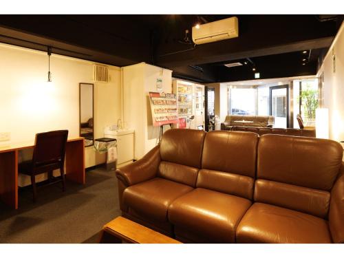 a living room with a leather couch and a table at Hotel Suntargas Otsuka in Tokyo