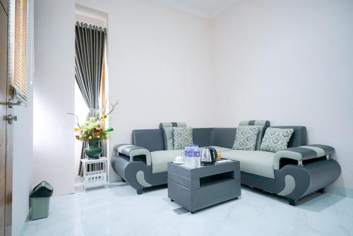 a living room with a couch and a coffee table at Sans Bougenville Lampung in Lampung