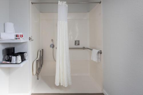 a white shower curtain in a white bathroom at Rodeway Inn Milpitas near Great Mall in Milpitas