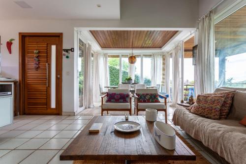 uma sala de estar com um sofá e uma mesa em Praia de Geriba - Fantastica Vista Mar em Búzios