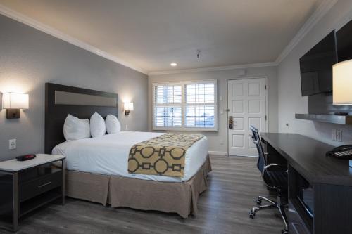 Habitación de hotel con cama y escritorio en Rodeway Inn Milpitas near Great Mall, en Milpitas