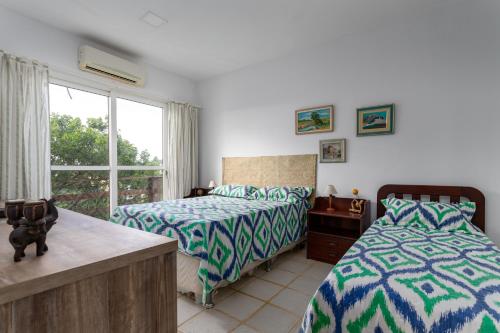 Un dormitorio con dos camas y una ventana en Praia de Geriba - Fantastica Vista Mar, en Búzios