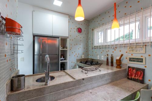 a kitchen with a sink and a refrigerator at Praia de Geriba - Fantastica Vista Mar in Búzios