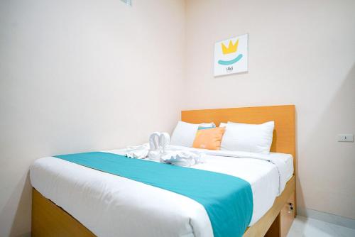 a bedroom with a large bed with blue and white sheets at Sans Bougenville Lampung in Lampung