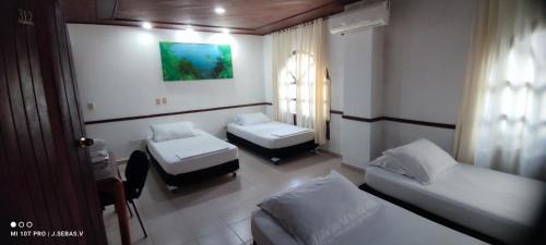 una piccola camera con due letti e una finestra di Hotel Costa Choco a Bahía Solano