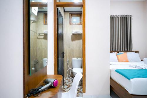 Dormitorio pequeño con cama y ducha en Sans Bougenville Lampung, en Lampung