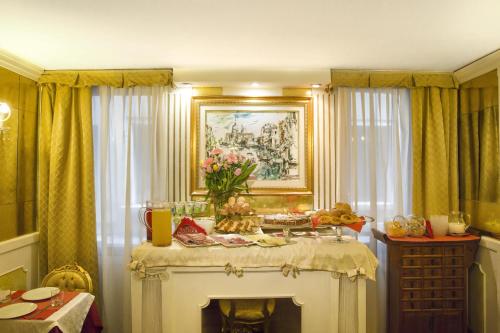 a room with a table with flowers on it at Hotel Noemi in Venice