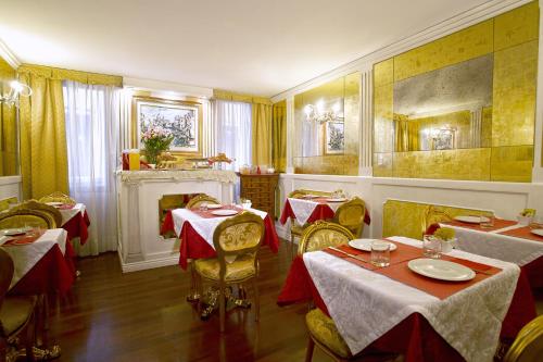 a restaurant with tables and chairs and a fireplace at Hotel Noemi in Venice
