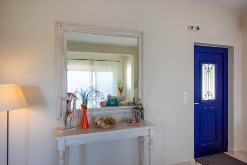シヴォタにあるVilla Pegasusの鏡付きテーブルと青いドアが備わる部屋