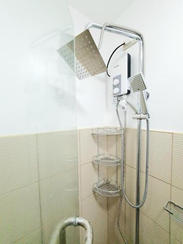 a shower with a shower head in a bathroom at Green 2 Residences Scandi-Industrial Hotel Type Interior in Dasmariñas