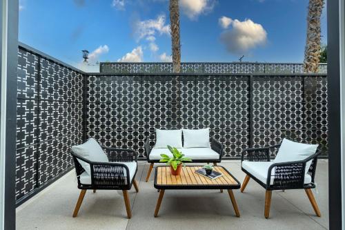 a patio with two chairs and a table and two chairs at Onsen Hotel and Spa in Desert Hot Springs