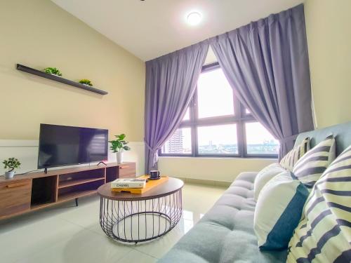 ein Wohnzimmer mit einem Sofa und einem TV in der Unterkunft M Vertica By Minsu in Kuala Lumpur