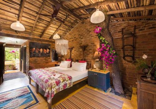 a bedroom with a bed and a tree in it at Turia Villa Canacona Palolem in Canacona