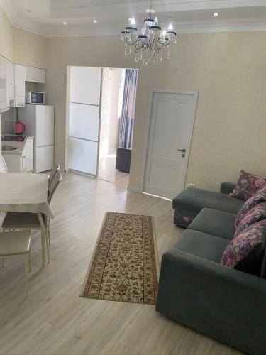 salon z kanapą i stołem oraz kuchnia w obiekcie 3х комнатная квартира жк Арай w mieście Ałma-Ata