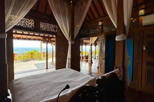 a bedroom with a bed and a view of the ocean at Villa Borobudur Resort in Borobudur