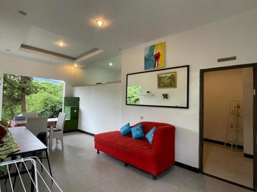 - un salon avec un canapé rouge et une table dans l'établissement Bantal Guling Villa, à Lembang