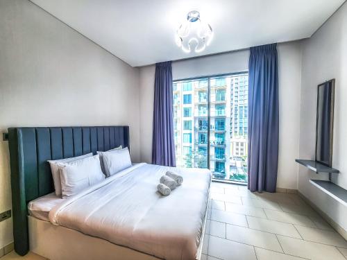 a large bed in a room with a large window at STAY BY LATINEM Luxury 1BR Holiday Home G6524 near Burj Khalifa in Dubai