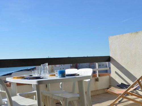 une table et des chaises sur un balcon avec vue sur l'océan dans l'établissement Appt T3 avec terrasse, clim, parking à Cap d'Agde, proche plage et commerces - FR-1-249-38, au Cap d'Agde