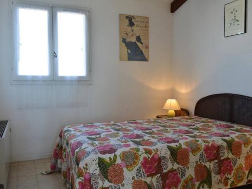une chambre avec un lit avec une couette dessus dans l'établissement Appt T3 avec terrasse, clim, parking à Cap d'Agde, proche plage et commerces - FR-1-249-38, au Cap d'Agde