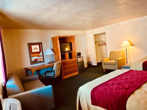 デル・リオにあるEcono Lodge Del Rioのベッド、デスク、椅子が備わるホテルルームです。