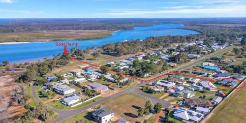 Eine Luftaufnahme eines Vororts mit einem roten Pfeil, der auf einen roten Bauernhof zeigt. in der Unterkunft Bali Elliott Heads - Coastal Holiday Home near Boat Ramp in Elliott Heads