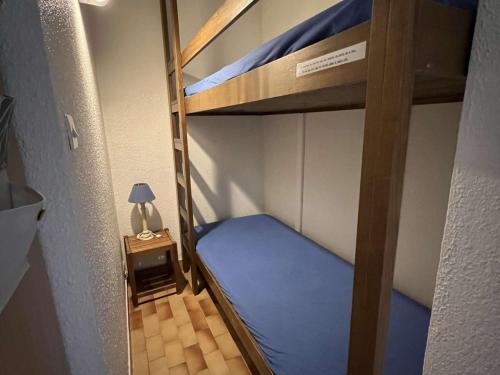 Ce lit superposé se trouve dans une petite chambre avec une lampe. dans l'établissement Studio Cabine au Cap d'Agde avec Parking, Piscine et Terrasse - FR-1-702-2, au Cap d'Agde
