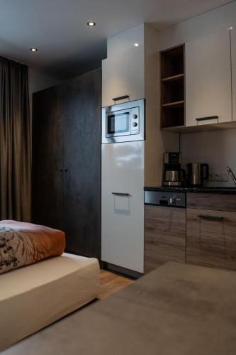 a small kitchen with a white refrigerator and a bed at Luxapart Haus 2 in Ladis