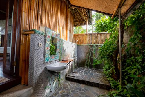 baño con lavabo en el lateral de un edificio en Villa Manuk, en Singaraja