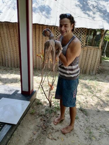 a man holding a dead animal in his arms at Werala Beach Resort in Kalpitiya