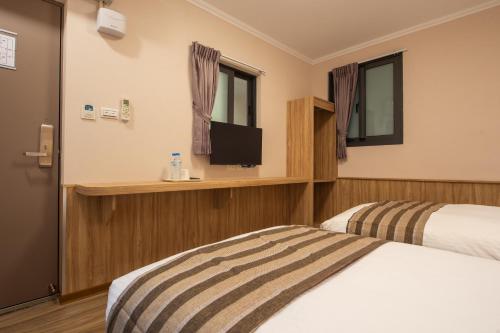 a hotel room with a bed and a television at Shan Shui Hostel in Hualien City