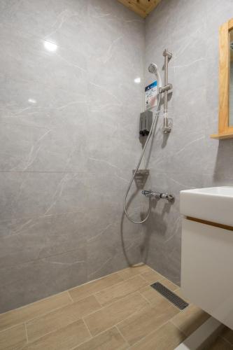 a bathroom with a shower and a sink at Shan Shui Hostel in Hualien City