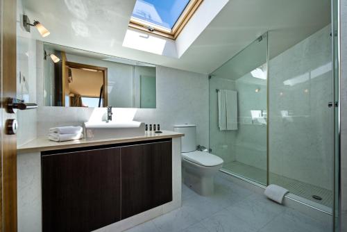 a bathroom with a sink and a toilet and a shower at Baia da Luz Resort in Luz