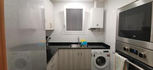 a kitchen with a sink and a washing machine at Valencia habitaciones in Barcelona