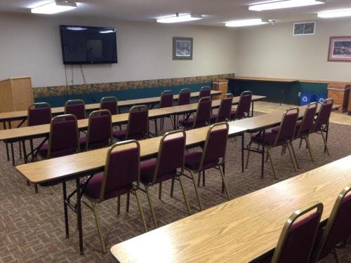 a conference room with wooden tables and chairs at Governors Inn a Travelodge by Wyndham in Pierre