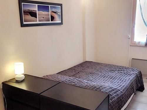 une petite chambre avec un lit et une table avec une lampe dans l'établissement T2 cabine proche plages et commerces avec garage à Bormes-les-Mimosas - FR-1-610-60, à Bormes-les-Mimosas