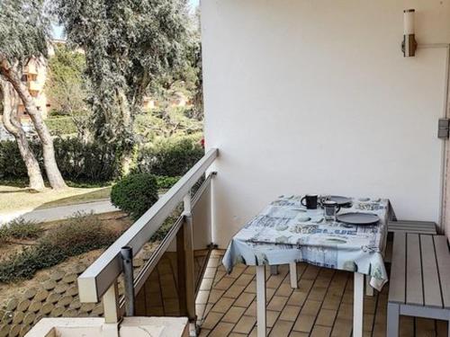 une table assise sur une terrasse couverte avec une nappe dans l'établissement T2 cabine proche plages et commerces avec garage à Bormes-les-Mimosas - FR-1-610-60, à Bormes-les-Mimosas